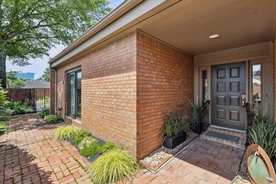 With Covered Entry, Brick Pavers, Decorative Side Panels,  and Lush Low-Maintenance Landscaping—Creating a Stylish and Inviting First Impression.