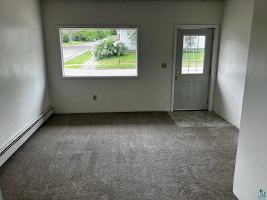 Doorway to outside featuring carpet floors and a baseboard radiator