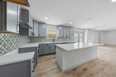 Kitchen featuring decorative backsplash, light woo