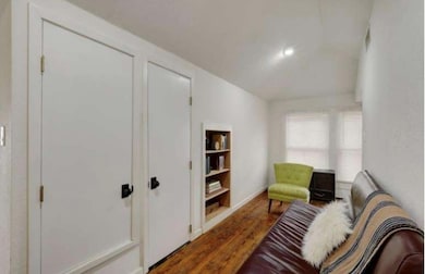 Sitting room with wood finished floors and vaulte