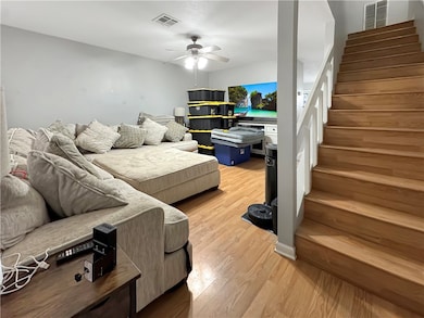 Living area featuring visible vents, light wood-st
