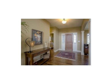 The entryway features gleaming wood flooring & hig
