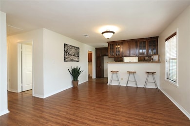 Kitchen with dark wood-type flooring, a peninsula,