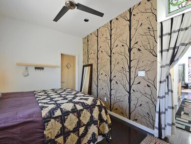 Bedroom with wallpapered walls, an accent wall, w