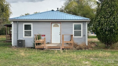 Rear view of house with a deck, a metal roof, and a yard