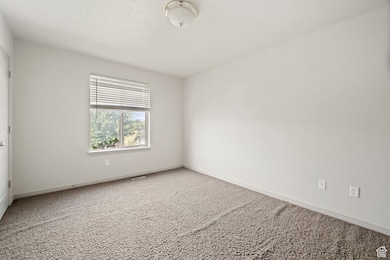 Carpeted spare room with baseboards