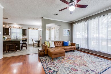 Another view of the living room open from kitchen area makes it easy for entertaining.  Crown molding, ceiling fan.
