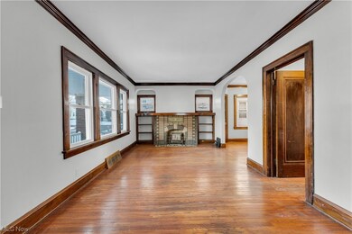 Unfurnished living room featuring ornamental molding, a fireplace, and light hardwood / wood-style flooring