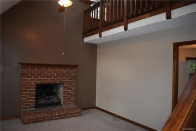 Living room with vaulted ceiling, skylights, gas fireplace and ceiling fan.