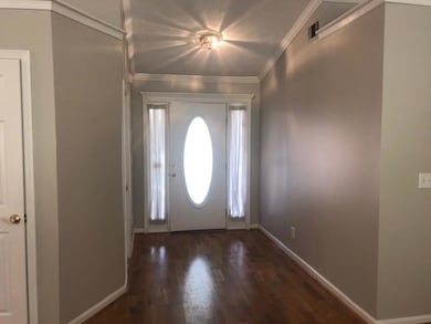 Foyer featuring baseboards, ornamental molding, wo