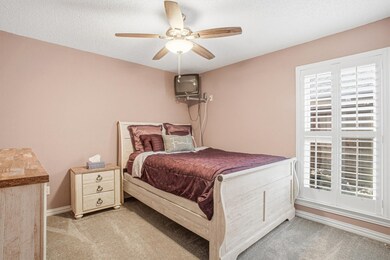 Bedroom featuring light colored carpet, a textured ceiling, and a ceiling fan