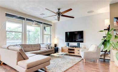 Living area featuring a ceiling fan, visible vents