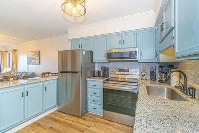 Kitchen featuring a sink, blue cabinets, appliances with stainless steel finishes, and crown molding