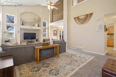 Living room with light carpet, high vaulted ceilin
