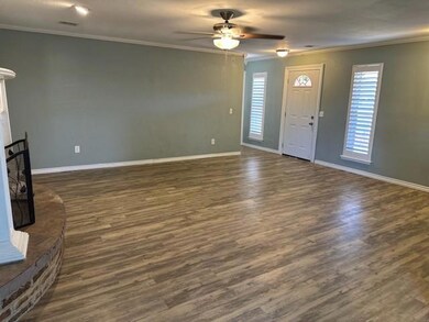 Unfurnished living room featuring ceiling fan, a w