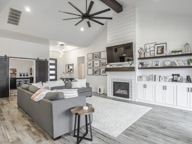 Stained exposed beam and floating shelves accent t