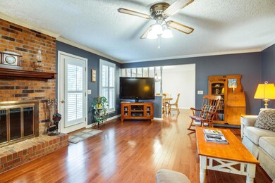 Large family room with wood burning fireplace. Also, door  leading out to deck. 