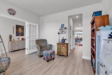 Sitting room featuring light wood-type flooring, baseboards, and french doors