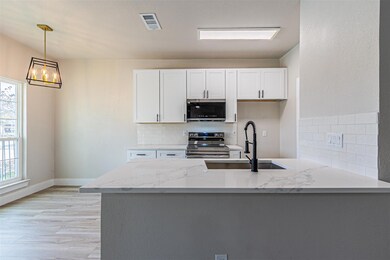 Kitchen with light stone counters, visible vents, 