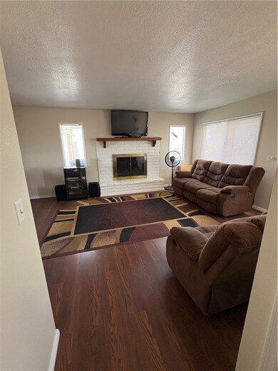 Living room featuring  finished floors, a brick fi