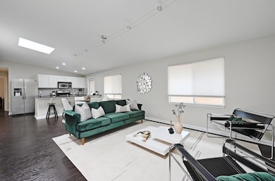 Living area with dark wood finished floors, vault