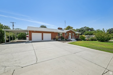 Ranch-style home with an attached garage, an attached carport, brick siding, and driveway