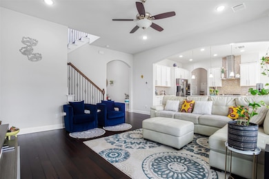 Living room with arched walkways, a ceiling fan, 