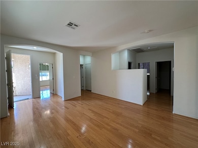 Empty room with light wood-style floors and arched