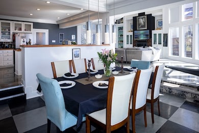 Dining space with crown molding, recessed lighting, dark flooring, and a fireplace