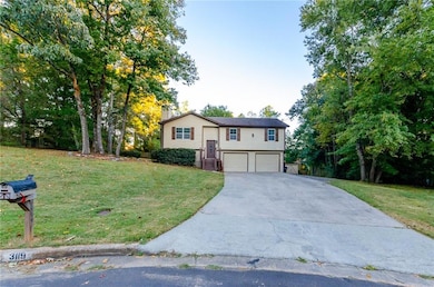 Bi-level home with concrete driveway, a front lawn, a garage, and a chimney