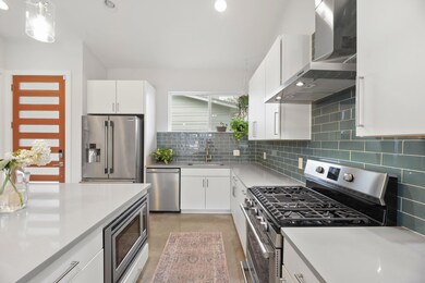 Kitchen featuring light countertops, a sink, wall