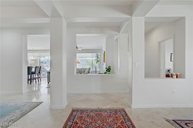 Foyer entrance with ceiling fan and baseboards