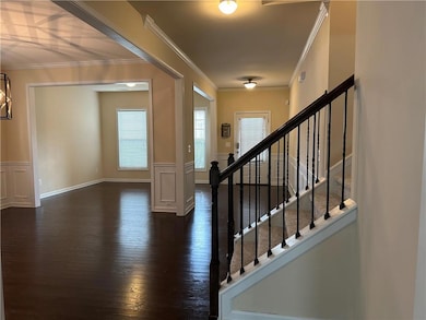 Entryway featuring wainscoting, ornamental molding