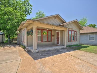 Bungalow-style home with driveway, covered porch.