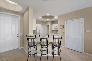 Kitchen with white appliances, a kitchen bar, kitc