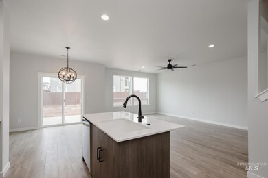 Kitchen with hanging light fixtures, light wood-type flooring, recessed lighting, open floor plan, and a ceiling fan