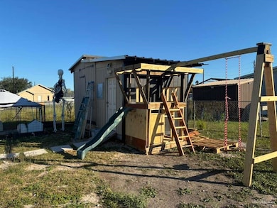 View of jungle gym featuring a fenced backyard and an outbuilding