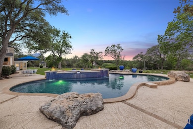 Pool at dusk featuring a patio and a pool with co
