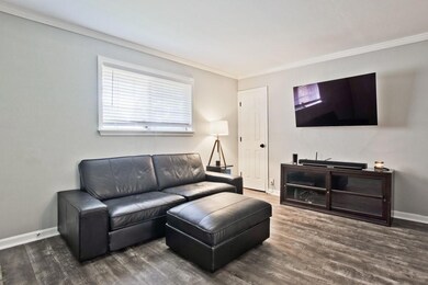 Living room featuring crown molding and wood finished floors