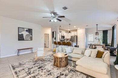 Living room featuring a ceiling fan and light tile patterned floors