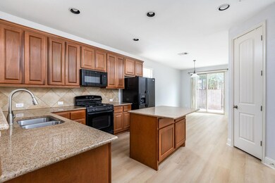 Kitchen featuring black appliances, brown cabinet