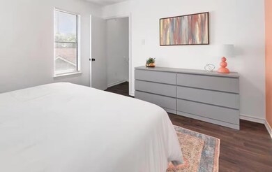 Bedroom with dark wood finished floors and basebo