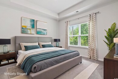 Bedroom with carpet flooring and a raised ceiling