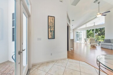 Hallway featuring high vaulted ceiling and light w