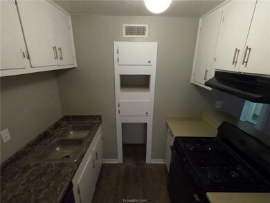 Kitchen featuring exhaust hood, visible vents, a s