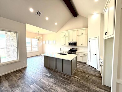 Kitchen with decorative backsplash, recessed lighting, a center island with sink, a chandelier, and appliances with stainless steel finishes