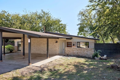 Mid-century inspired home featuring brick siding and an attached carport