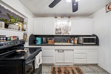 Kitchen featuring ceiling fan, black electric rang