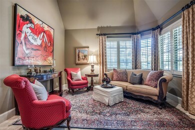 Formal living room with fireplace, lovely window treatments & plantation shutters.