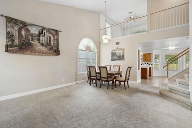 Dining room with ceiling fan, a towering ceiling,